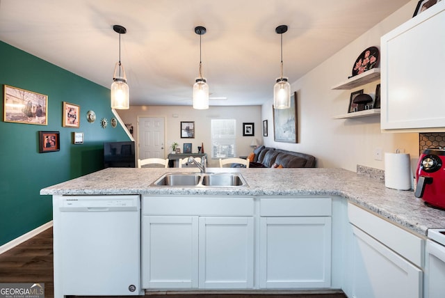 kitchen with a sink, open shelves, open floor plan, a peninsula, and dishwasher
