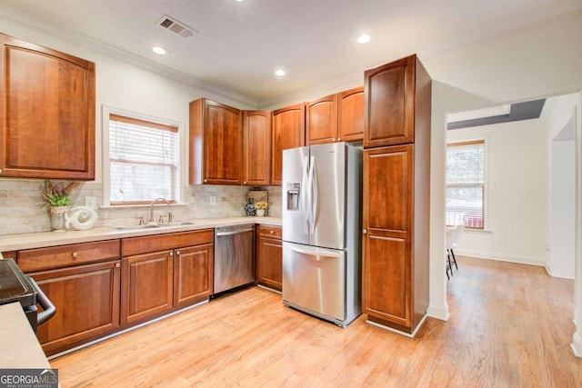 kitchen featuring plenty of natural light, light hardwood / wood-style floors, sink, and appliances with stainless steel finishes