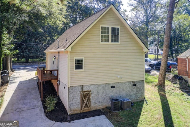 view of side of property with central AC and a yard