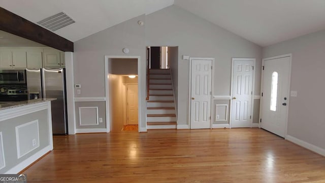 entryway with light hardwood / wood-style floors and lofted ceiling