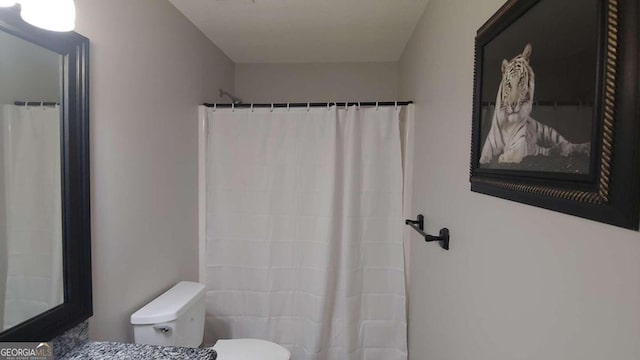 bathroom featuring a shower with curtain, vanity, and toilet