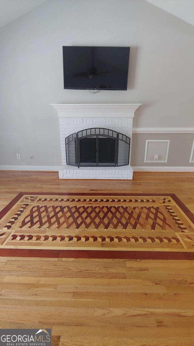 details with wood-type flooring and a brick fireplace