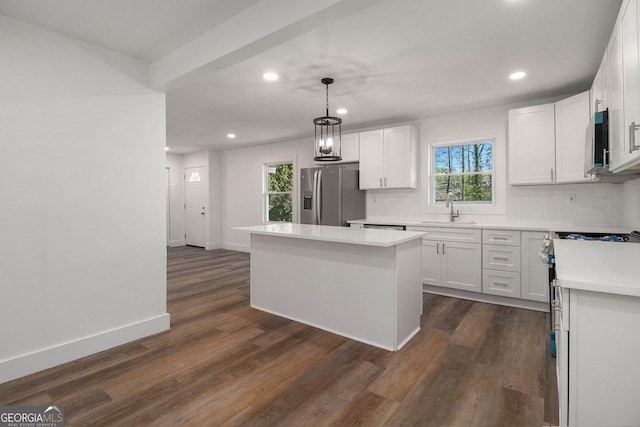 kitchen featuring white cabinets, sink, a kitchen island, and stainless steel appliances