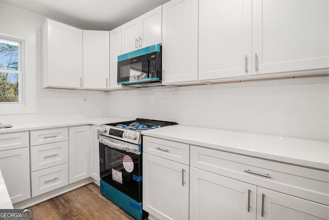 kitchen featuring backsplash, white cabinetry, dark wood-type flooring, and stainless steel range oven