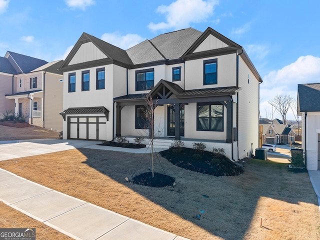 view of front of property featuring a garage, a standing seam roof, board and batten siding, concrete driveway, and metal roof