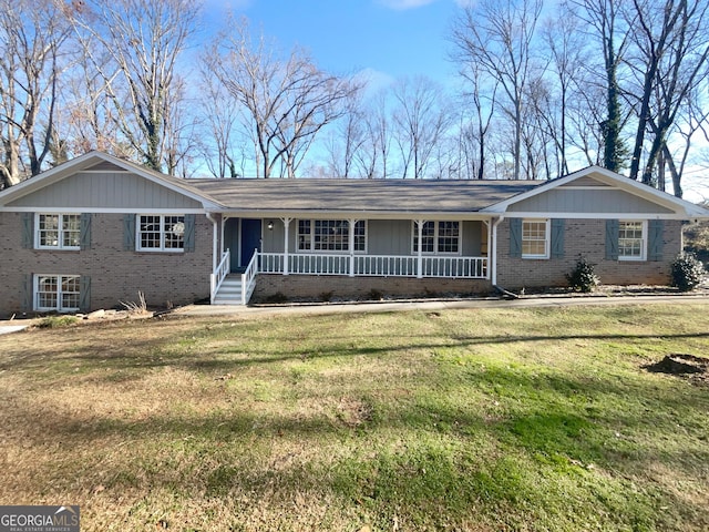 single story home featuring covered porch and a front yard