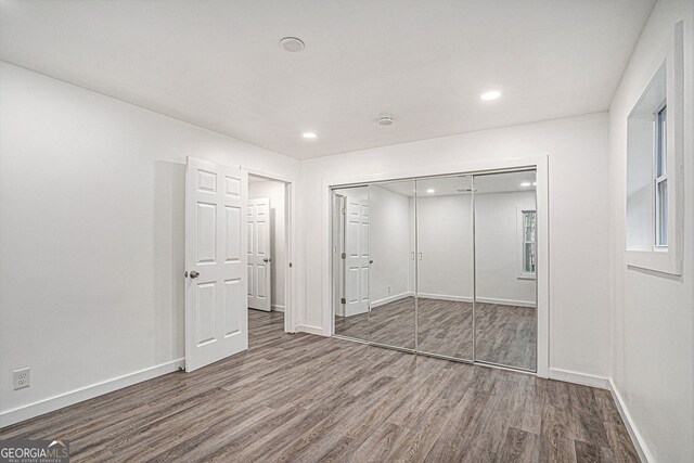 unfurnished bedroom featuring wood-type flooring and a closet