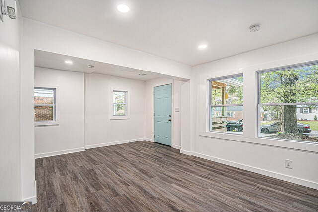 empty room with a healthy amount of sunlight and dark hardwood / wood-style floors