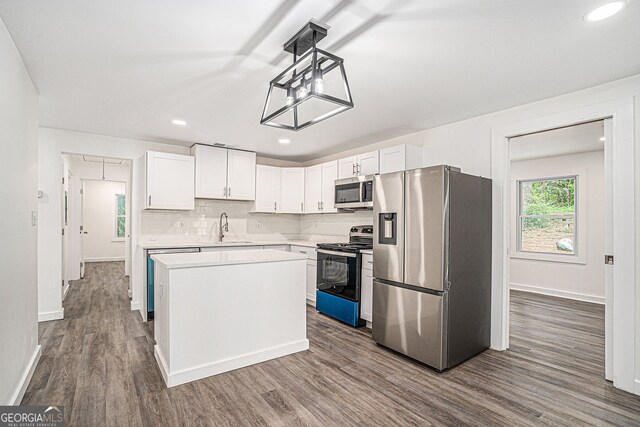 kitchen with sink, a center island, dark hardwood / wood-style floors, stainless steel appliances, and white cabinets