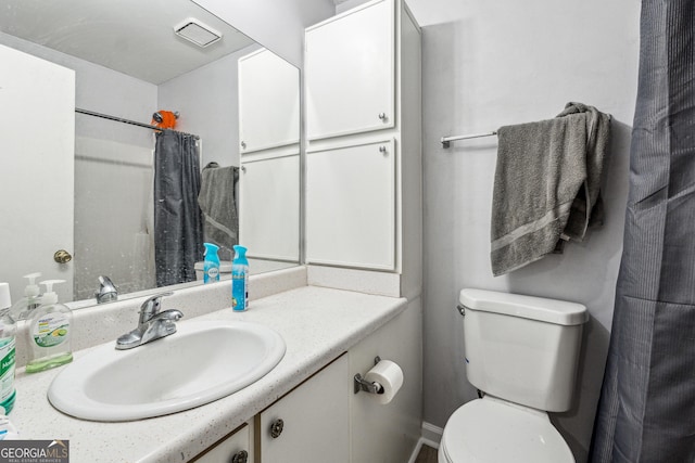 bathroom with a shower with shower curtain, vanity, and toilet