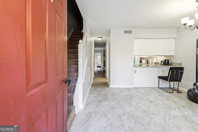 foyer featuring an inviting chandelier and sink