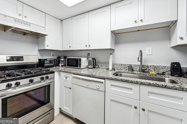 kitchen featuring white cabinetry, sink, light hardwood / wood-style flooring, stone countertops, and white appliances