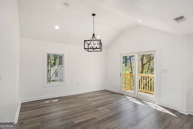 unfurnished dining area with lofted ceiling, dark hardwood / wood-style floors, and a notable chandelier