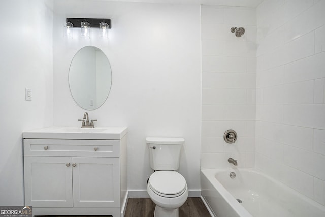 full bathroom featuring vanity, toilet, tiled shower / bath combo, and wood-type flooring