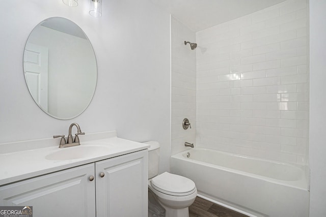 full bathroom featuring tiled shower / bath combo, vanity, hardwood / wood-style floors, and toilet