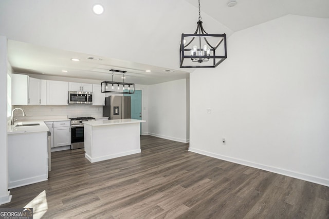 kitchen featuring appliances with stainless steel finishes, decorative light fixtures, white cabinetry, sink, and decorative backsplash