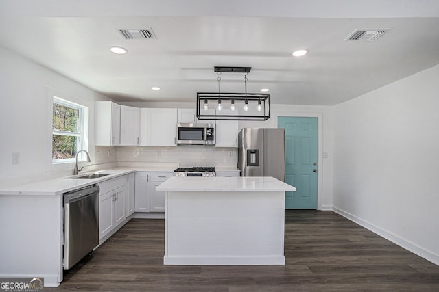 kitchen with pendant lighting, white cabinetry, appliances with stainless steel finishes, and sink