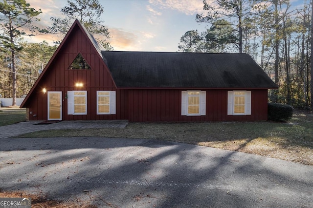 a-frame home featuring a shingled roof and a detached garage