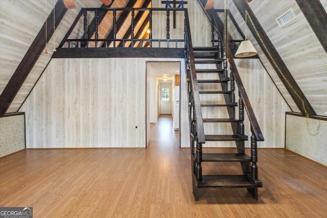 staircase with wood ceiling, visible vents, wood finished floors, and beamed ceiling