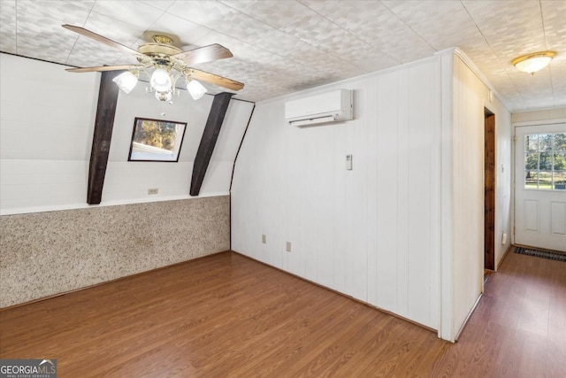 unfurnished room featuring wood finished floors, ceiling fan, and a wall mounted AC