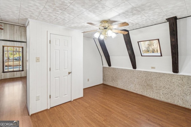 unfurnished room featuring a ceiling fan, vaulted ceiling, and wood finished floors