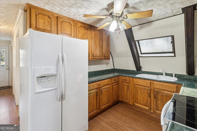 kitchen with electric stove, brown cabinets, wood finished floors, white fridge with ice dispenser, and a sink