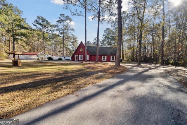 view of front of property featuring a front lawn, driveway, and a barn