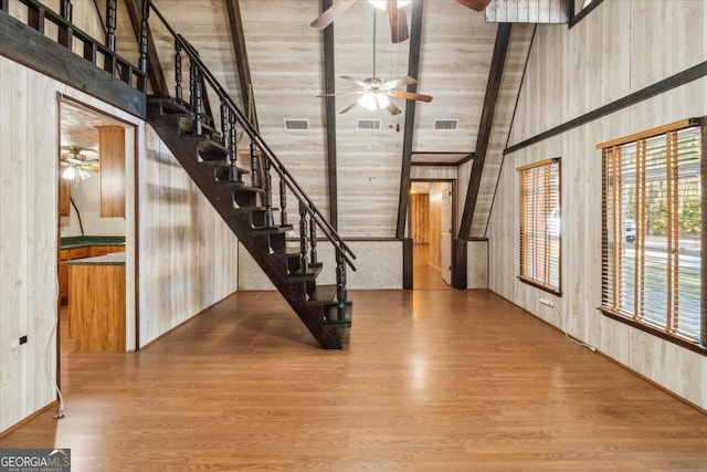 entryway with ceiling fan, stairs, high vaulted ceiling, and wood finished floors