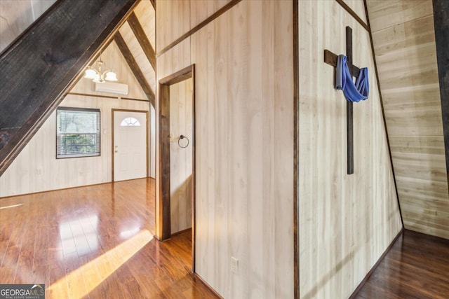 additional living space featuring lofted ceiling with beams, hardwood / wood-style flooring, and wooden walls