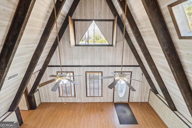 additional living space featuring high vaulted ceiling, visible vents, beam ceiling, and wood finished floors