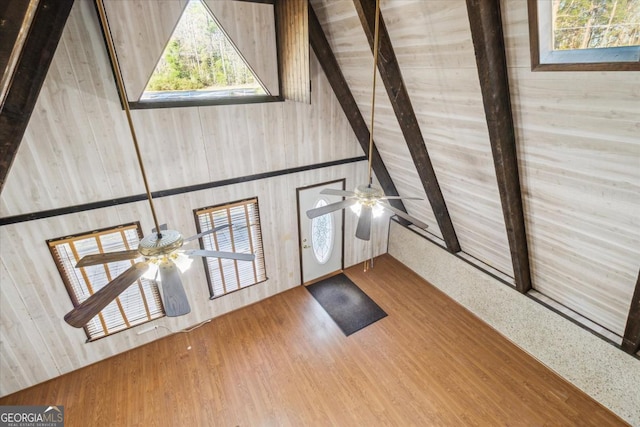 entrance foyer featuring ceiling fan, a high ceiling, beamed ceiling, and wood finished floors