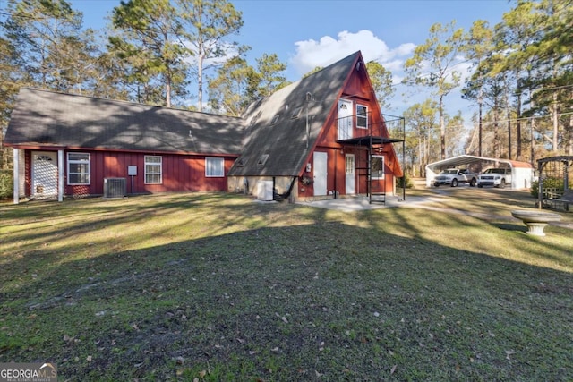 back of property featuring central air condition unit, a carport, driveway, and a lawn