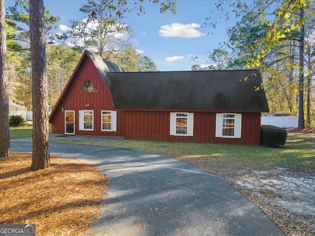 exterior space featuring aphalt driveway and a front yard