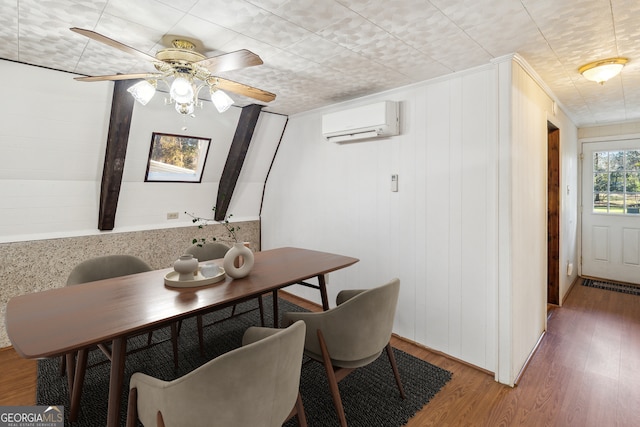 dining room featuring ceiling fan, an AC wall unit, and wood finished floors