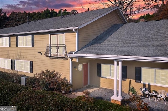 back house at dusk featuring a patio area