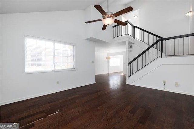 unfurnished living room featuring ceiling fan, dark hardwood / wood-style flooring, and high vaulted ceiling