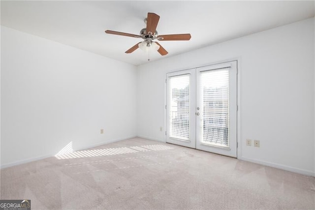 carpeted empty room with ceiling fan and french doors