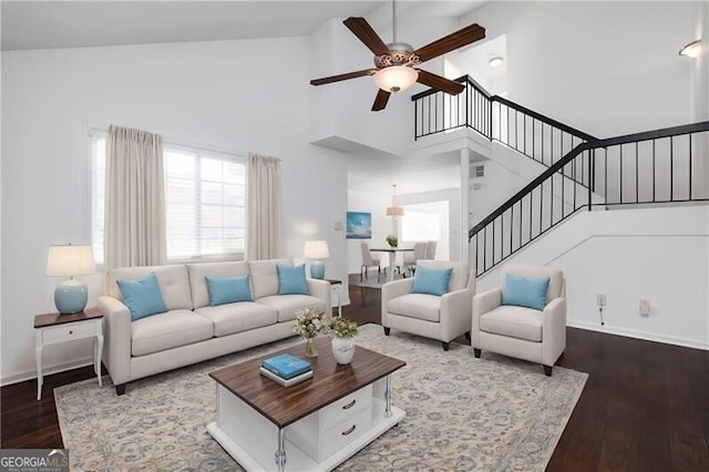 living room featuring dark hardwood / wood-style floors, high vaulted ceiling, and ceiling fan