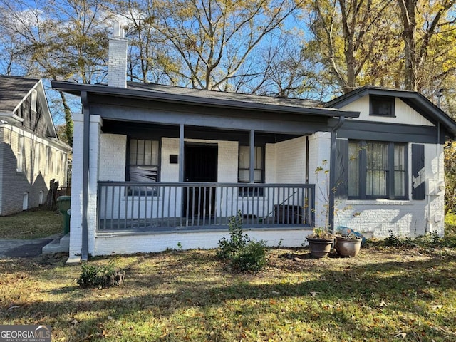 view of front of property with covered porch and a front yard