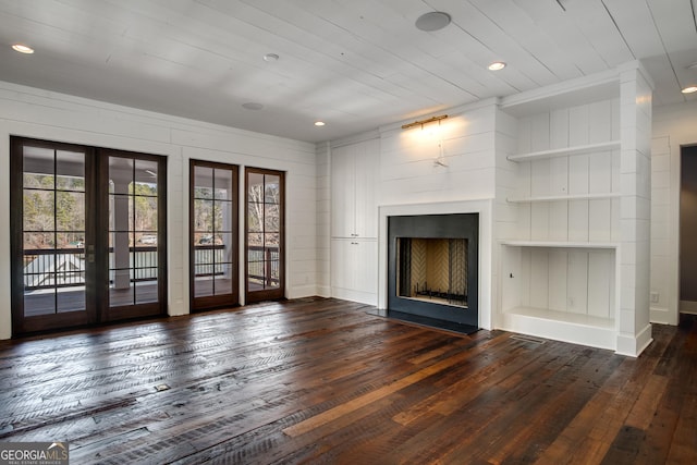 unfurnished living room featuring dark hardwood / wood-style flooring, wood ceiling, and french doors