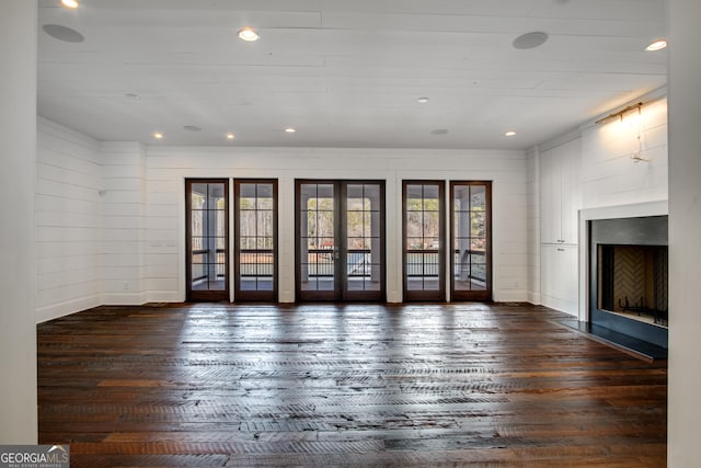 unfurnished living room featuring french doors and dark wood-type flooring