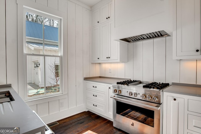 kitchen with dark hardwood / wood-style floors, white cabinetry, custom range hood, and stainless steel range