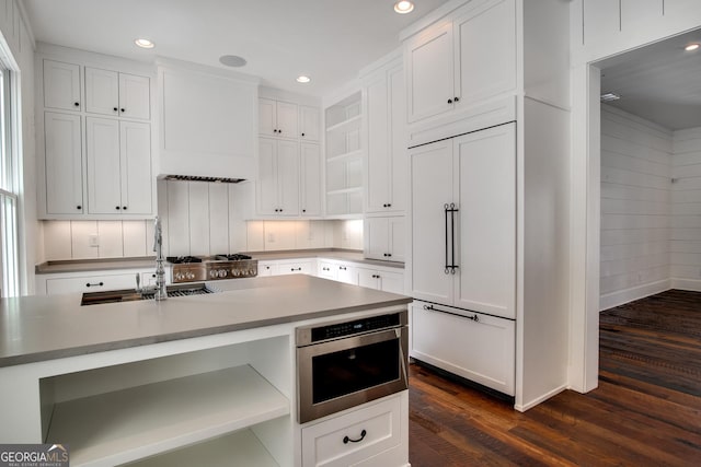 kitchen with white cabinetry, dark hardwood / wood-style flooring, paneled built in refrigerator, and sink