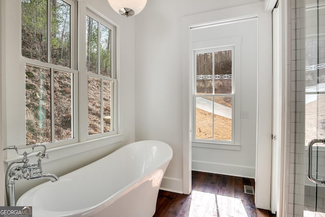 bathroom with a bath and wood-type flooring