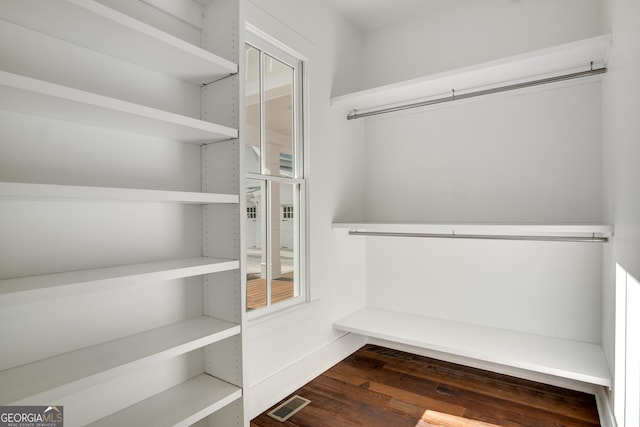 spacious closet with dark hardwood / wood-style floors