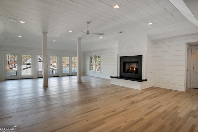 unfurnished living room with light hardwood / wood-style floors, ceiling fan, wood walls, and wood ceiling