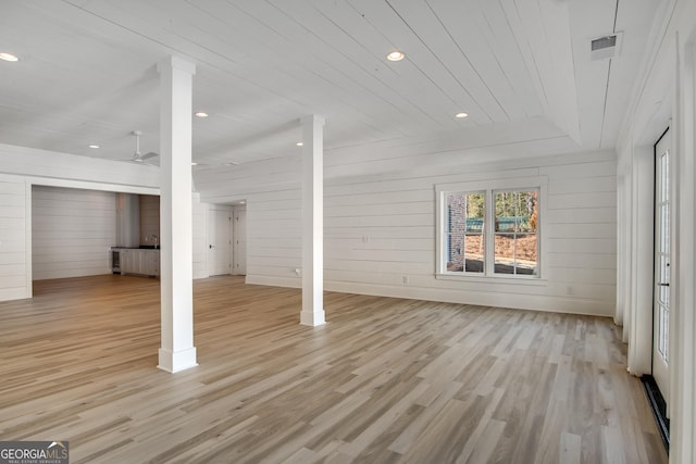 basement with wood walls, ceiling fan, light hardwood / wood-style floors, and wood ceiling