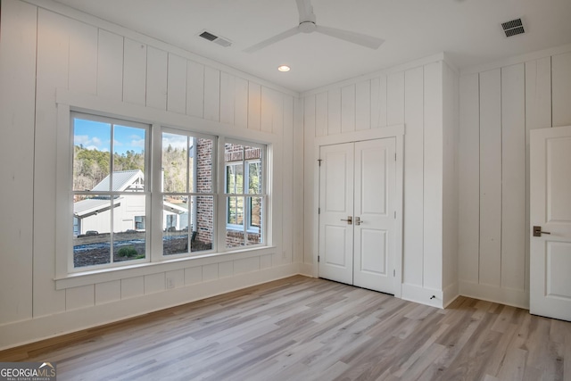 unfurnished bedroom with ceiling fan, a closet, and light hardwood / wood-style flooring