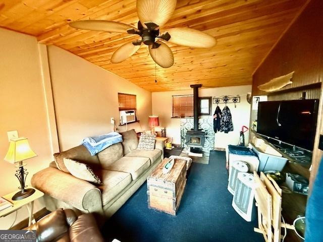 living room featuring carpet flooring, lofted ceiling, a wood stove, and wood ceiling