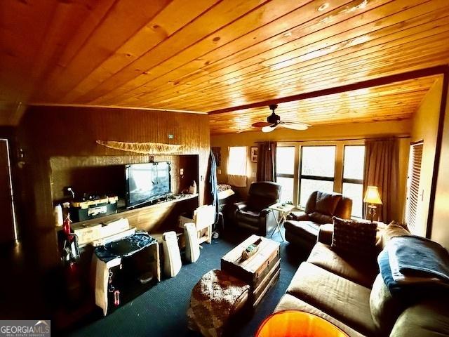 living room featuring ceiling fan, wood walls, and wood ceiling